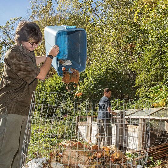 A+student+dumping+a+bin+of+compost